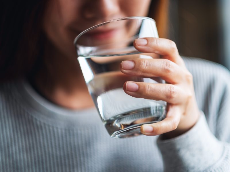 A resident holds a glass of tap water — Lee County officials say recent elevated fluoride readings were limited in scope and pose no immediate risk, though the system remains under regulatory review.
