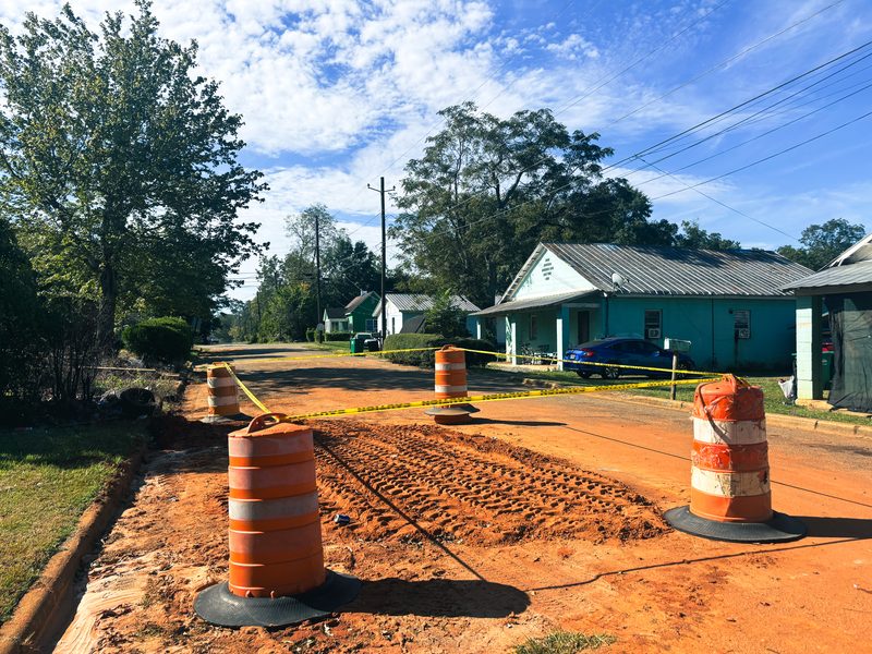 Traffic barrels and caution tape surround a dirt-filled section of Walnut Street in Dawson after a roadway collapse.